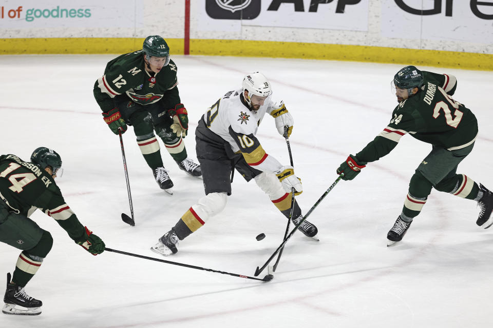 Vegas Golden Knights center Nicolas Roy (10) handles the puck against Minnesota Wild defenseman Matt Dumba (24) during overtime in an NHL hockey game Monday, April 3, 2023, in St. Paul, Minn. (AP Photo/Stacy Bengs)