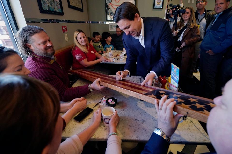 Republican presidential candidate, Florida Gov. Ron DeSantis, autographs a sign during a campaign stop, Tuesday, Oct. 24, 2023, in Londonderry, New Hampshire.