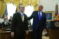 President Donald Trump congratulates Olympic gold medalist and former University of Iowa wrestling coach Dan Gable after awarding him the Presidential Medal of Freedom, the highest civilian honor, in the Oval Office of the White House, Monday, Dec. 7, 2020, in Washington. (AP Photo/Patrick Semansky)