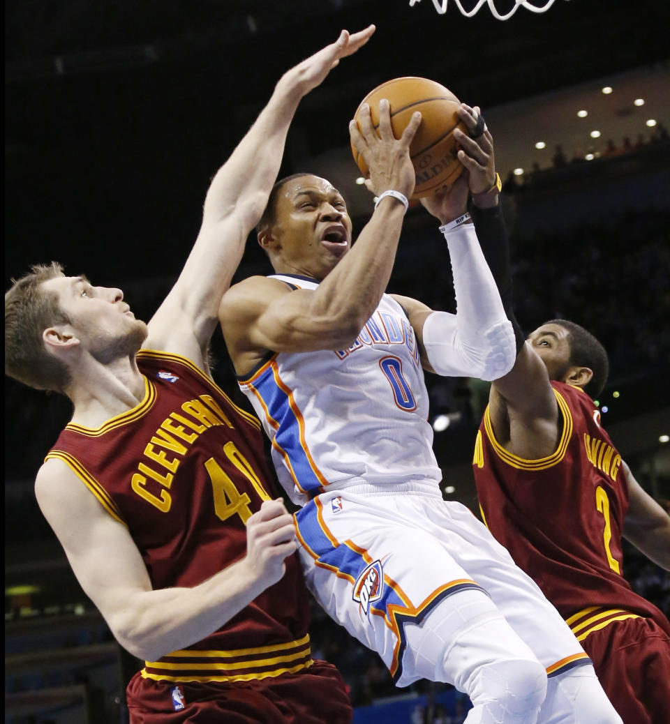 Oklahoma City Thunder guard Russell Westbrook (0) shoots between Cleveland Cavaliers center Tyler Zeller (40) and guard Kyrie Irving (2) during the fourth quarter of an NBA basketball game in Oklahoma City, Wednesday, Feb. 26, 2014. Cleveland won 114-104. (AP Photo/Sue Ogrocki)