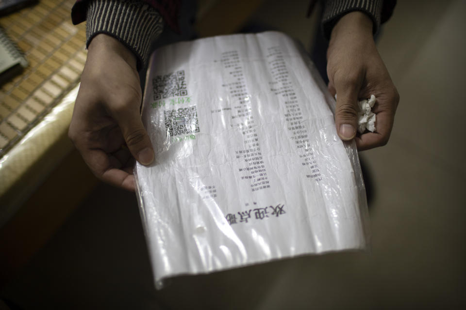 In this Dec. 5, 2019 photo, Wu Yi, who has struggled with Oxycontin abuse, holds a playlist of songs he sings for money while sitting in his rented room in Shenzhen, southern China's Guangdong Province. Officially, pain pill abuse is an American problem, not a Chinese one. But people in China have fallen into opioid abuse the same way many Americans did, through a doctor's prescription. And despite China's strict regulations, online trafficking networks, which facilitated the spread of opioids in the U.S., also exist in China. (AP Photo/Mark Schiefelbein)