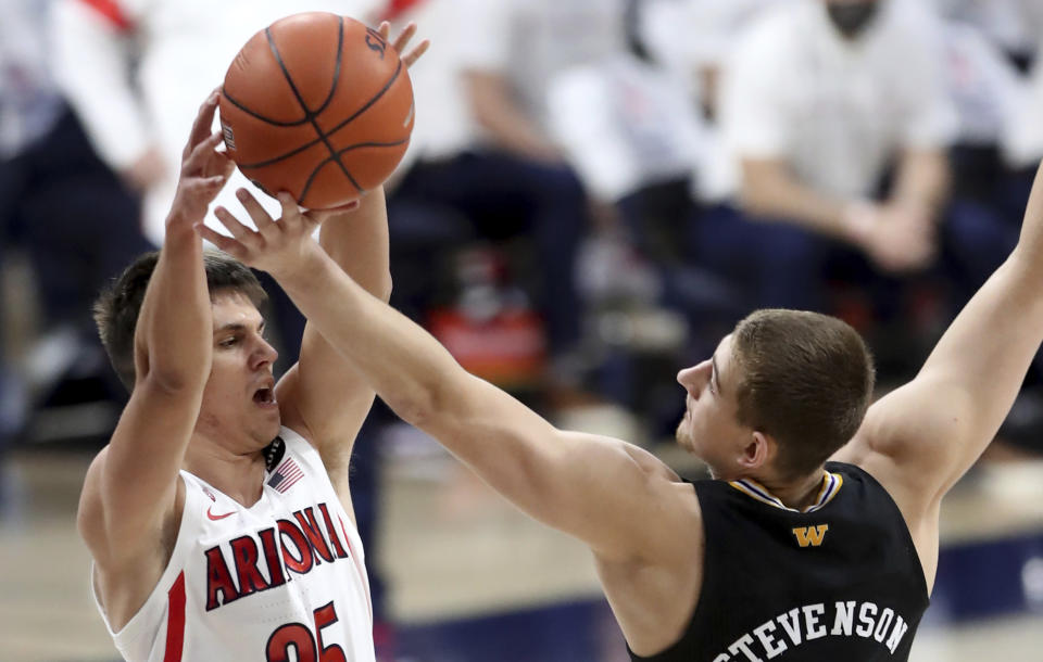 Arizona guard Kerr Kriisa (25) gets his pass deflected Washington guard Erik Stevenson (10) near the top of the key in the first half of an NCAA college basketball game Saturday, Feb. 27, 2021, in Tucson, Ariz. (Kelly Presnell/Arizona Daily Star via AP)