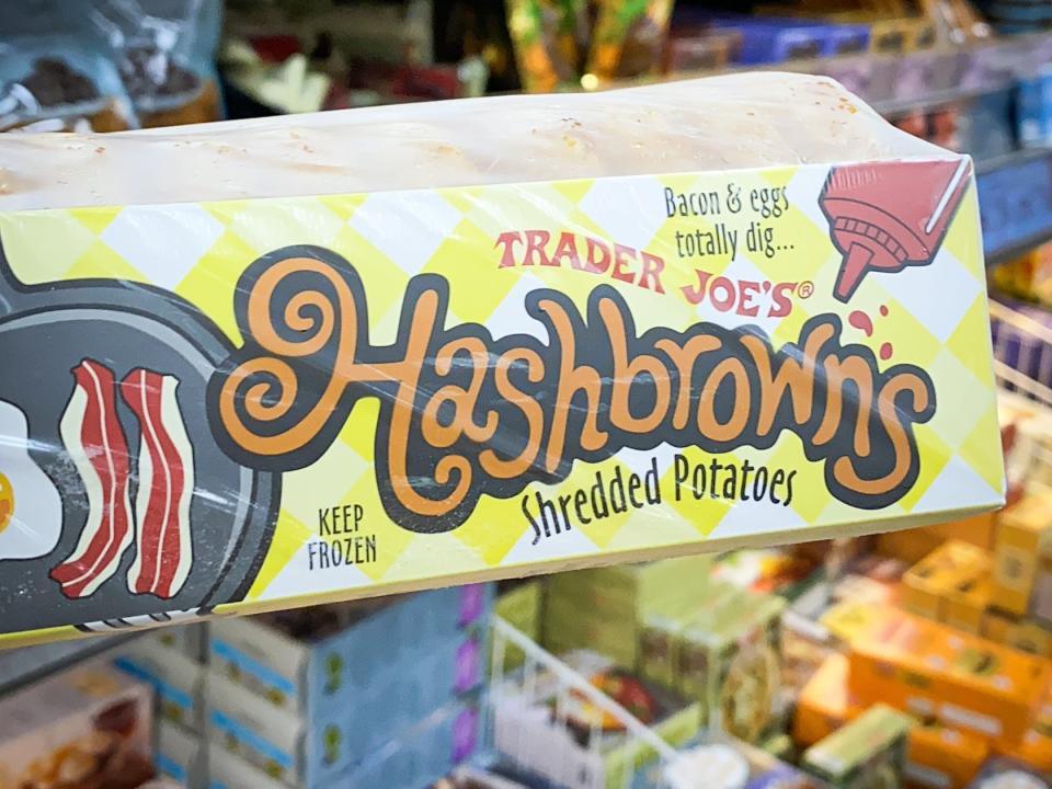 hand holding package of frozen hash browns at trader joes