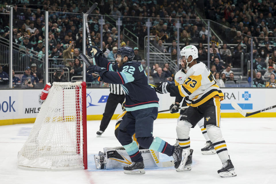 Seattle Kraken right wing Oliver Bjorkstrand (22) celebrates after his goal as Pittsburgh Penguins defenseman Pierre-Olivier Joseph (73) looks on during the first period of an NHL hockey game Thursday, Feb. 29, 2024, in Seattle. (AP Photo/Jason Redmond)