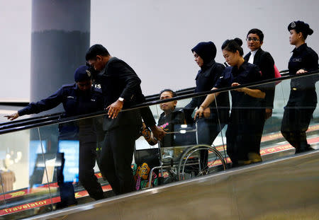 Indonesian Siti Aisyah, who is on trial for the killing of Kim Jong Nam, the estranged half-brother of North Korea's leader, is escorted as she revisits the Kuala Lumpur International Airport 2 in Sepang, Malaysia October 24, 2017. REUTERS/Lai Seng Sin/Files