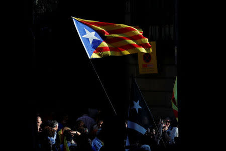 People wave an Estelada (Catalan separatist flag) near Sant Jaume Square after the Catalan regional parliament declares independence from Spain in Barcelona, Spain October 27, 2017. REUTERS/Yves Herman