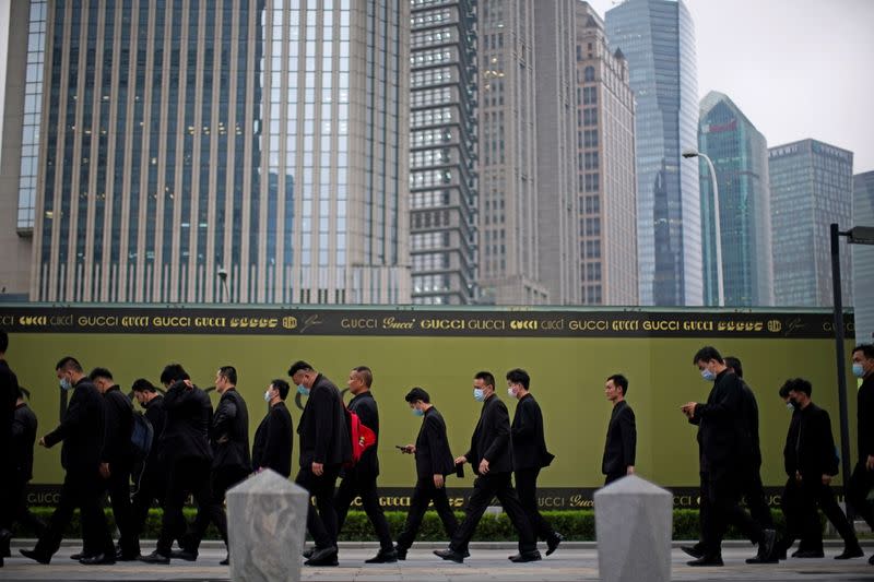 Security guards walk along at financial district of Lujiazui in Shanghai