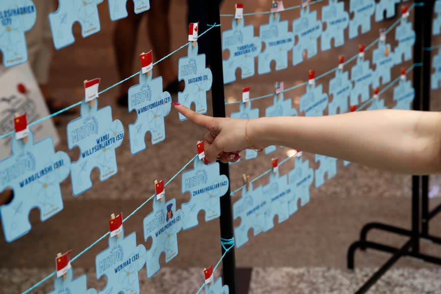 A family member of passengers on board of the missing Malaysia Airlines Flight 370 points at the names tag of the missing passengers during the tenth annual remembrance event at a shopping mall, in Subang Jaya, on the outskirts of Kuala Lumpur, Malaysia, Sunday, March 3, 2024. Ten years ago, a Malaysia Airlines Flight 370, had disappeared March 8, 2014 while en route from Kuala Lumpur to Beijing with 239 people on board. (AP Photo/FL Wong)