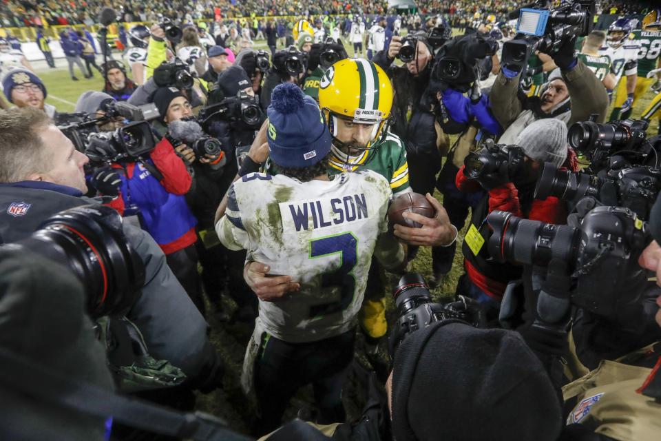 Green Bay Packers' Aaron Rodgers talks to Seattle Seahawks' Russell Wilson after an NFL divisional playoff football game Sunday, Jan. 12, 2020, in Green Bay, Wis. The Packers won 28-23 to advance to the NFC Championship. (AP Photo/Mike Roemer)