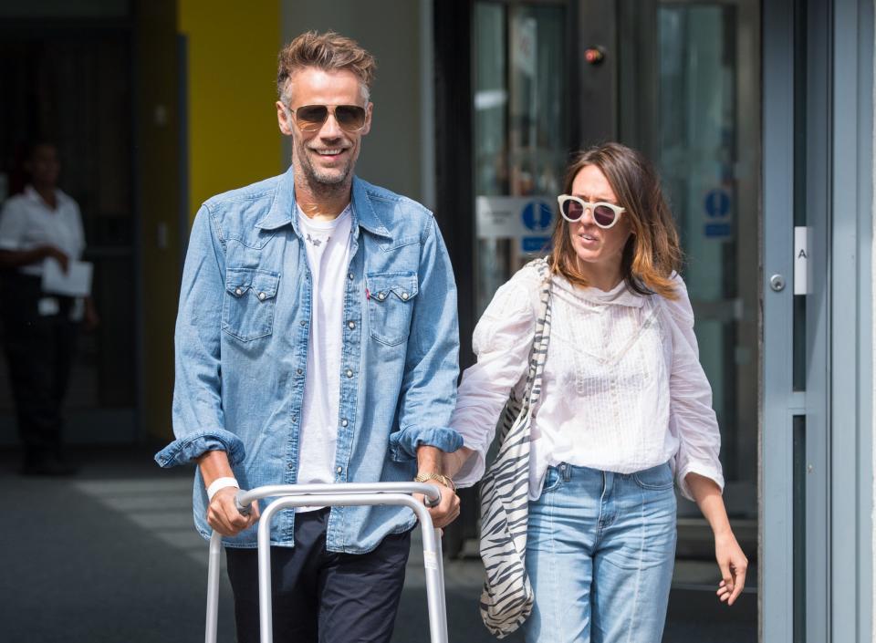 Richard Bacon with his wife as he left hospital last year (PA)