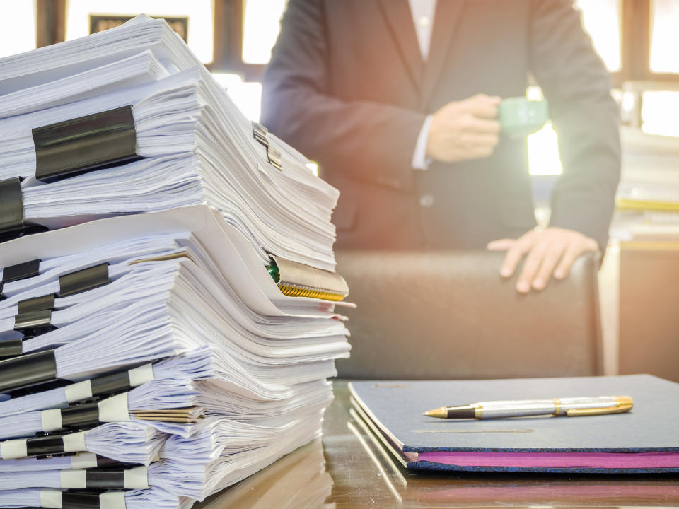 Close up of business documents stack on businessman background