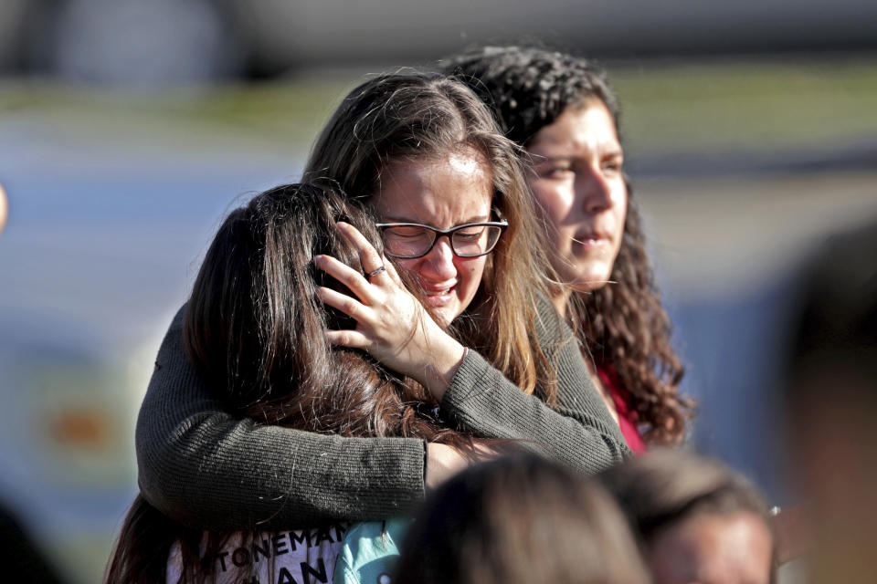 FILE - In this Wednesday, Feb. 14, 2018 file photo, students released from a lockdown embrace following a shooting at Marjory Stoneman Douglas High School in Parkland, Fla. The 12 jurors and 10 alternates chosen this past week to decide whether Cruz is executed will be exposed to horrific images and emotional testimony, but must deal with any mental anguish alone. ( (John McCall/South Florida Sun-Sentinel via AP, File)