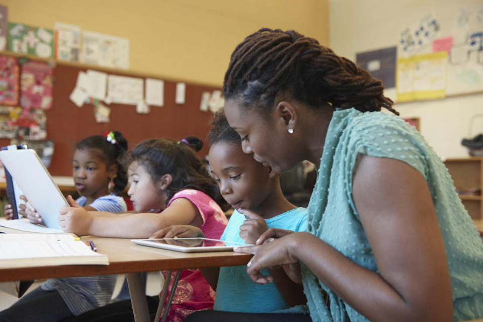 A teacher helps a student with an in-class assignment