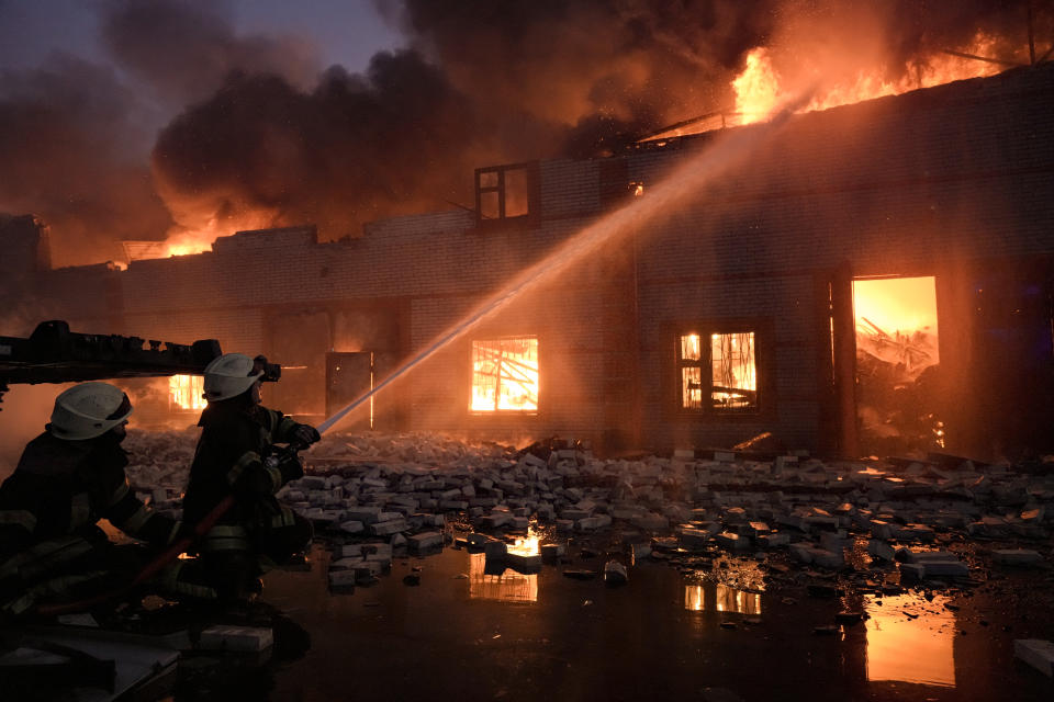 Ukrainian firefighters extinguish a blaze at a warehouse after a bombing on the outskirts of Kyiv, Ukraine, Thursday, March 17, 2022. Russian forces destroyed a theater in Mariupol where hundreds of people were sheltering Wednesday and rained fire on other cities, Ukrainian authorities said, even as the two sides projected optimism over efforts to negotiate an end to the fighting. (AP Photo/Vadim Ghirda)