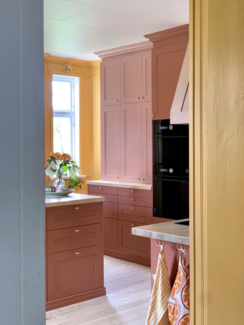 Bright yellow-orange kitchen with terracotta cabinets and drawers