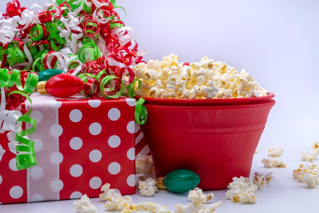 wrapped christmas presents beside a red bowl of popcorn