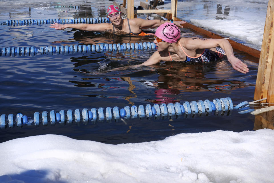 Andie Nelson, of Virginia, right, races Martha Wood, of Manchester, Mass., during the 200 meter freestyle competition during the winter swimming festival on frozen Lake Memphremagog, Friday, Feb. 23, 2024, in Newport, Vermont. (AP Photo/Charles Krupa)
