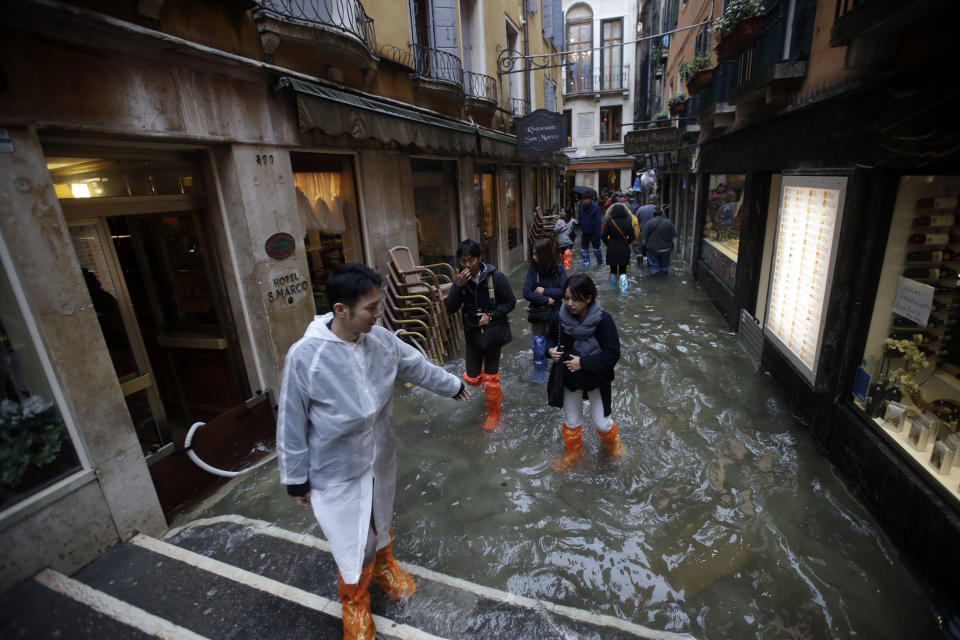 Tourists came prepared as they took to the flooded streets (AP)