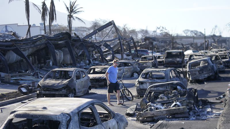 A man walks through wildfire wreckage Friday, Aug. 11, 2023, in Lahaina, Hawaii. Hawaii emergency management records show no indication that warning sirens sounded before people ran for their lives from wildfires on Maui that wiped out a historic town.