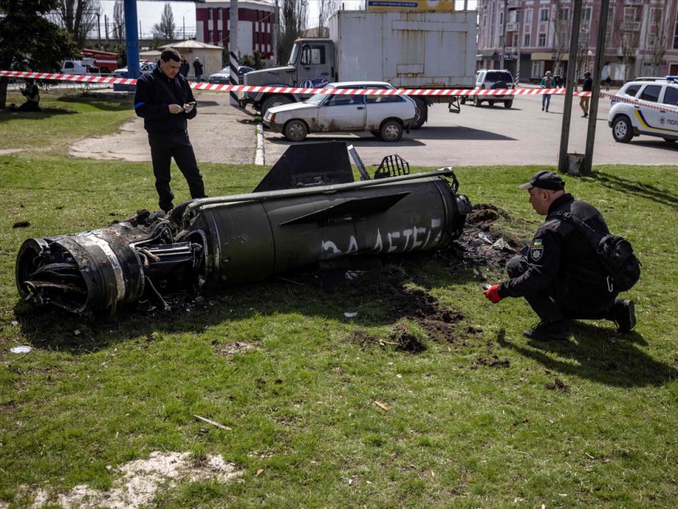 Ukrainian police inspect the remains of a large rocket with the words ‘for the children’ in Russian next to the main building of a train station in Kramatorsk (AFP/Getty)