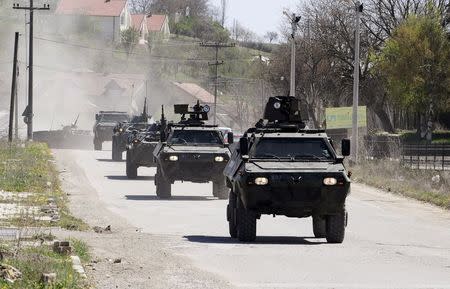 Police armed personnel carriers travel down a road to the village of Goshince from where police officers were taken hostage overnight, north of the capital Skopje April 21, 2015. REUTERS/Ognen Teofilovski