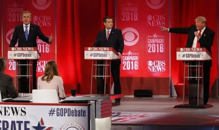 Republican U.S. presidential candidates former Governor Jeb Bush (L) and businessman Donald Trump (R) speak at the same time as they debate the record of Bush's brother, former President George W. Bush, as Senator Ted Cruz (C) looks on at the Republican U.S. presidential candidates debate sponsored by CBS News and the Republican National Committee in Greenville, South Carolina February 13, 2016. REUTERS/Jonathan Ernst