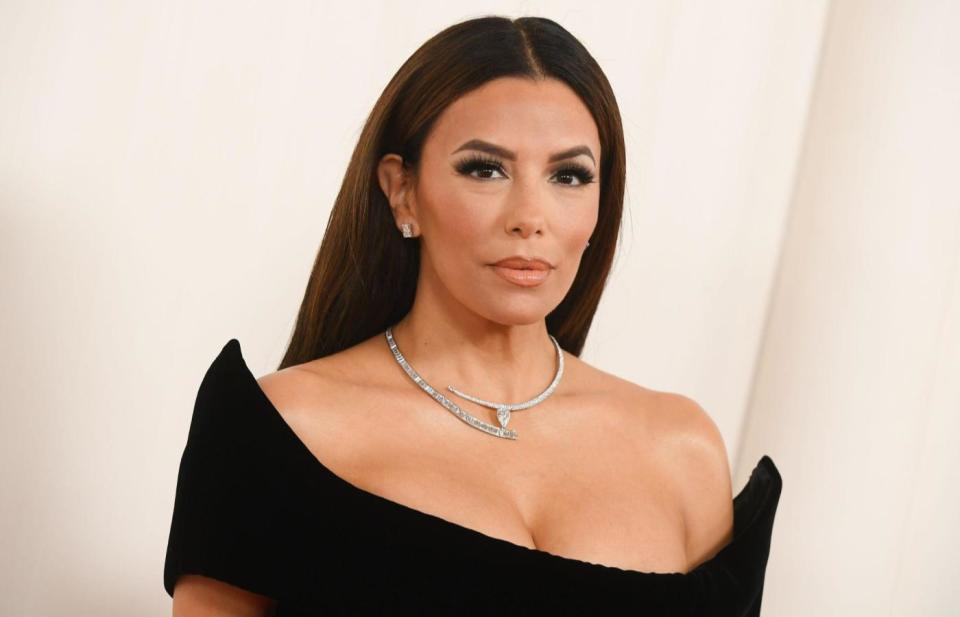 Eva Longoria wearing a black dress with straight hair on a red carpet. 