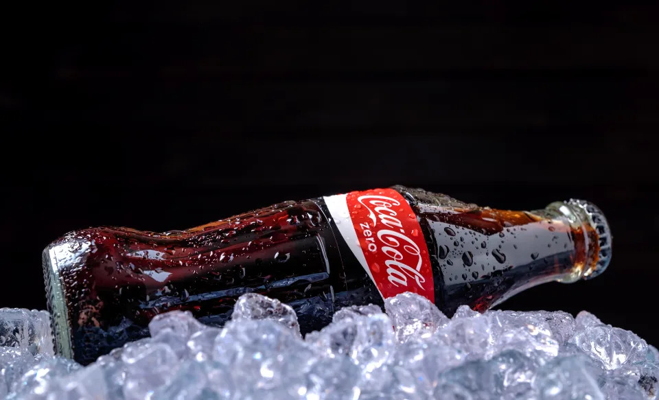 Minsk, Belarus - August 16, 2015: Minsk, Belarus-August 16, 2015: Classic Bottle of Coca-Cola Zero on the ice over blue wooden background. Coca-Cola is a carbonated soft drink sold in stores, restaurants, and vending machines throughout the world.