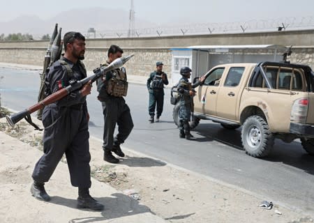 Afghan police officers keep watch at the site of a car bomb blast in Kabul