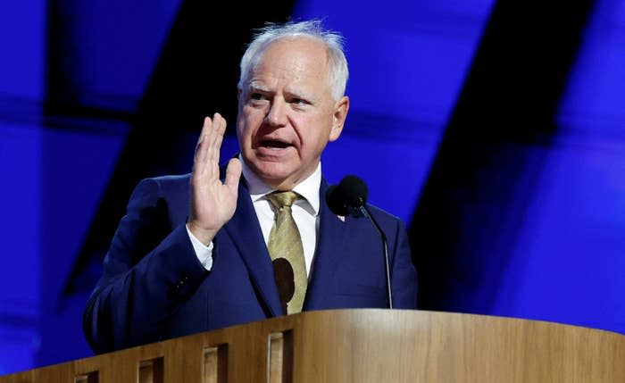 Tim Walz speaks at a podium with one hand raised