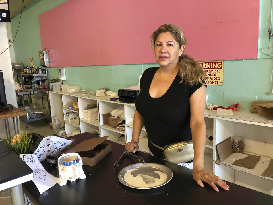 Dona Beltran, owner of M Bakery is seen behind her bakery counter in Garden Grove, Calif., Thursday, Aug. 8, 2019. She said the suspect came in late Wednesday afternoon and took the entire cash register. She said she ran to a nearby dental office to safety when she saw she was being robbed. A man "full of anger" stabbed, slashed and robbed his way across two Southern California cities in a bloody rampage that killed several people and wounded a few others who were apparently targeted at random, authorities said. (AP Photo/Amy Taxin)