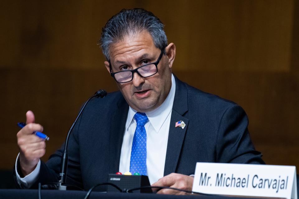 A man in a suit speaks while seated at a Senate hearing.