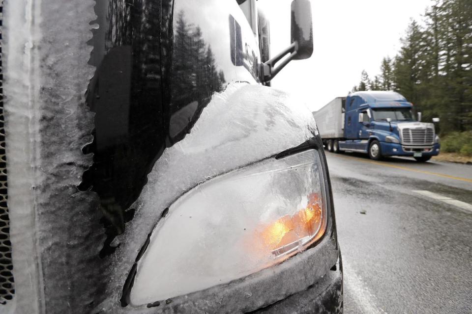 A truck remains partially covered with ice and parked after being forced to turn around on Snoqualmie Pass when Interstate 90 closed earlier Wednesday, Jan. 18, 2017, in North Bend, Wash. An ice storm shut down parts of major highways and interstates Wednesday in Oregon and Washington state and paralyzed the hardest hit towns along the Columbia River Gorge with up to 2 inches of ice coating the ground in some places. In Washington state, I-90, the main highway connecting western and eastern Washington, was to remain closed over Snoqualmie Pass because of hazardous winter conditions. (AP Photo/Elaine Thompson)