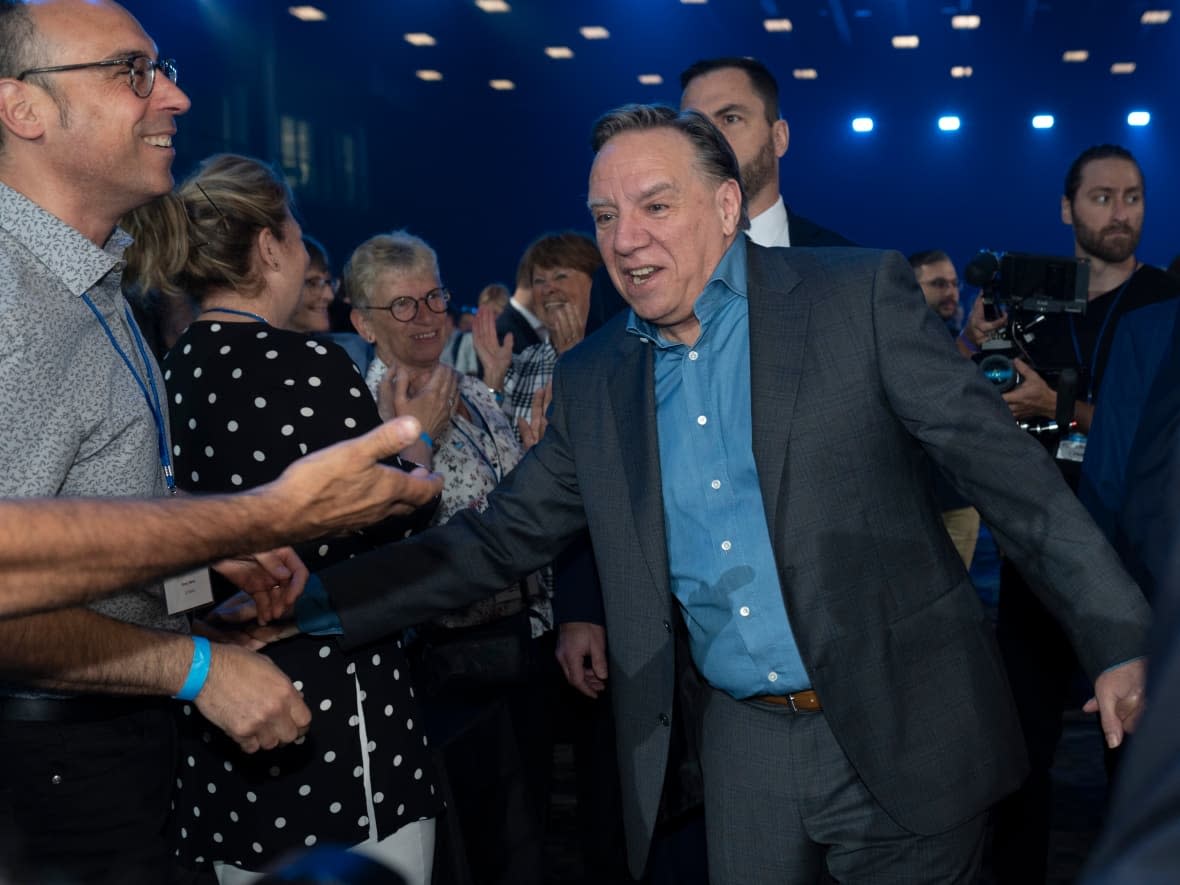 Quebec Premier François Legault shakes hand with delegates as he enters a Coalition Avenir Quebec annual congress, in Drummondville, Que. (Jacques Boissinot/The Canadian Press - image credit)