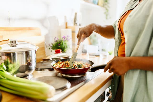 <p>Anchiy/Getty</p> A woman cooking (stock image)