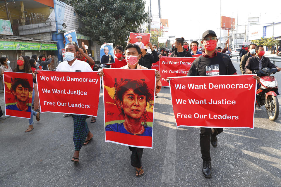 Protesters holding an image of deposed leader Aung San Suu Kyi & President Win Myint in Mandalay, Myanmar on Monday, Feb. 8, 2021. A protest against Myanmar's one-week-old military government swelled rapidly Monday morning as opposition to the coup grew increasingly bold. (AP Photo)