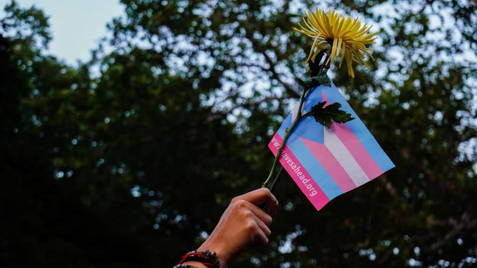 A person holds a transgender pride flag and a flower during a Black Trans Liberation protest in New York, United States, May 31, 2023. - Amr Alfiky/Reuters