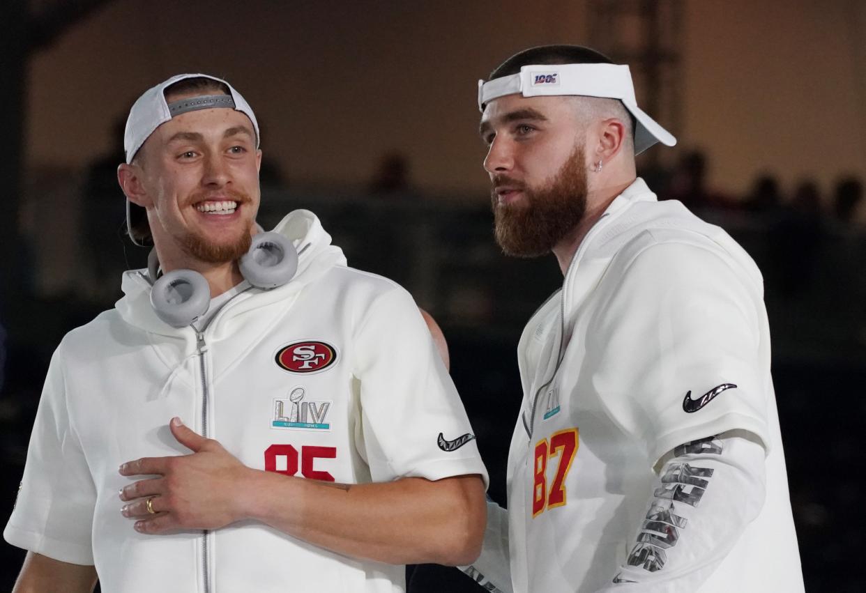 49ers tight end George Kittle (85) greets Chiefs tight end Travis Kelce (87) during Super Bowl LIV Opening Night at Marlins Park.
