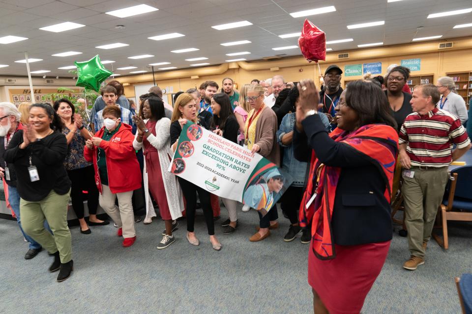 Highland Park High School staff celebrate Tuesday with Topeka Public Schools superintendent Tiffany Anderson after taking a group photo with a banner showing the graduation rates exceeded 90%.