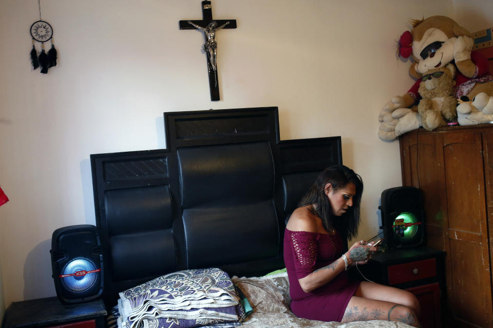 In this Aug. 17, 2019 photo, trans rights activist Kenya Cuevas text messages a friend while sitting in her bedroom , in Chalco, Mexico. Like most crime in the country, nearly all killings of LGBTQ members go unsolved and unpunished, leaving trans community leaders and activists largely on their own in pursuing long-denied justice. (AP Photo/Ginnette Riquelme)