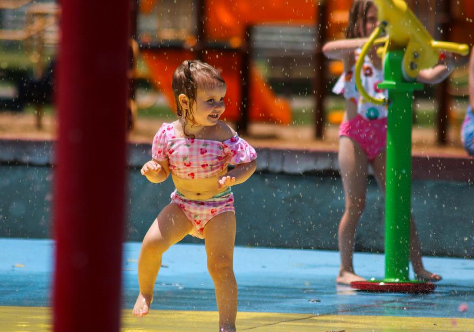 A toddler dances underneath a sprinkler at a splash pad in Jerry Ivey Memorial Park. The Salina Area United Way was awarded $400,000 in American Rescue Plan Act funds to help address local childcare needs.