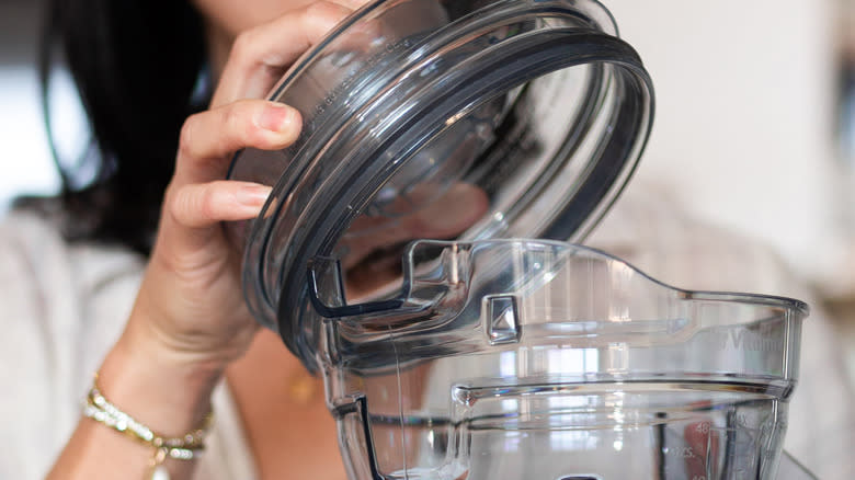 woman removing blender lid