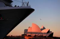 FILE PHOTO: A passenger stands aboard the Carnival Cruise Lines ship called the 'Carnival Spirit' as it sits docked opposite the Sydney Opera House