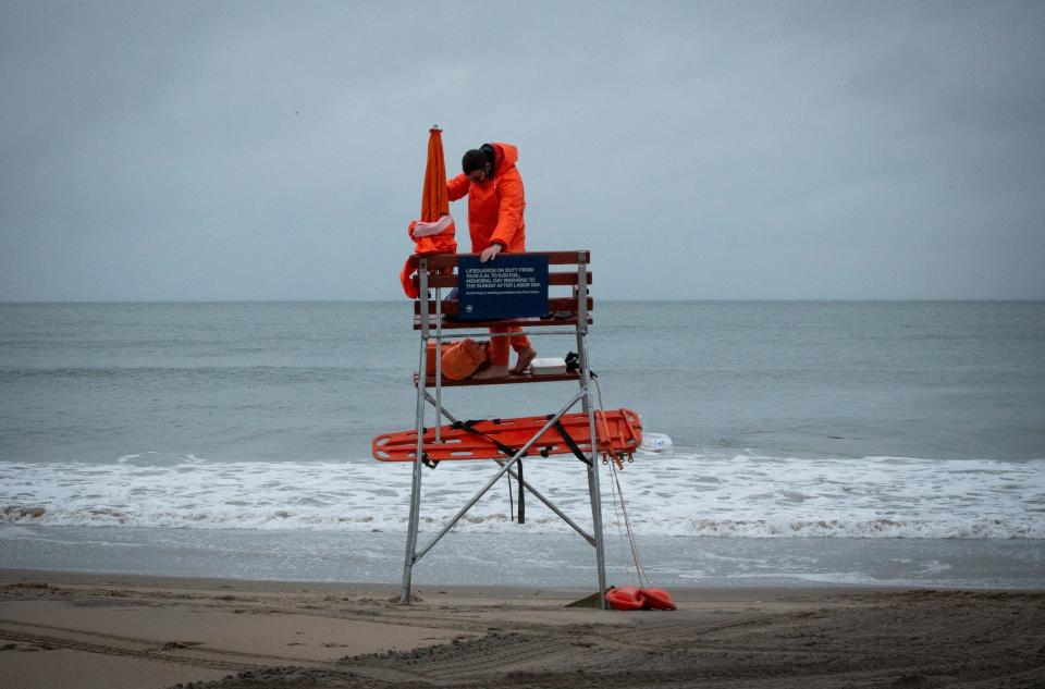 A lifeguard sets up his equipment as rain falls during Memorial Day weekend in Coney Island in New York on May 30, 2021.