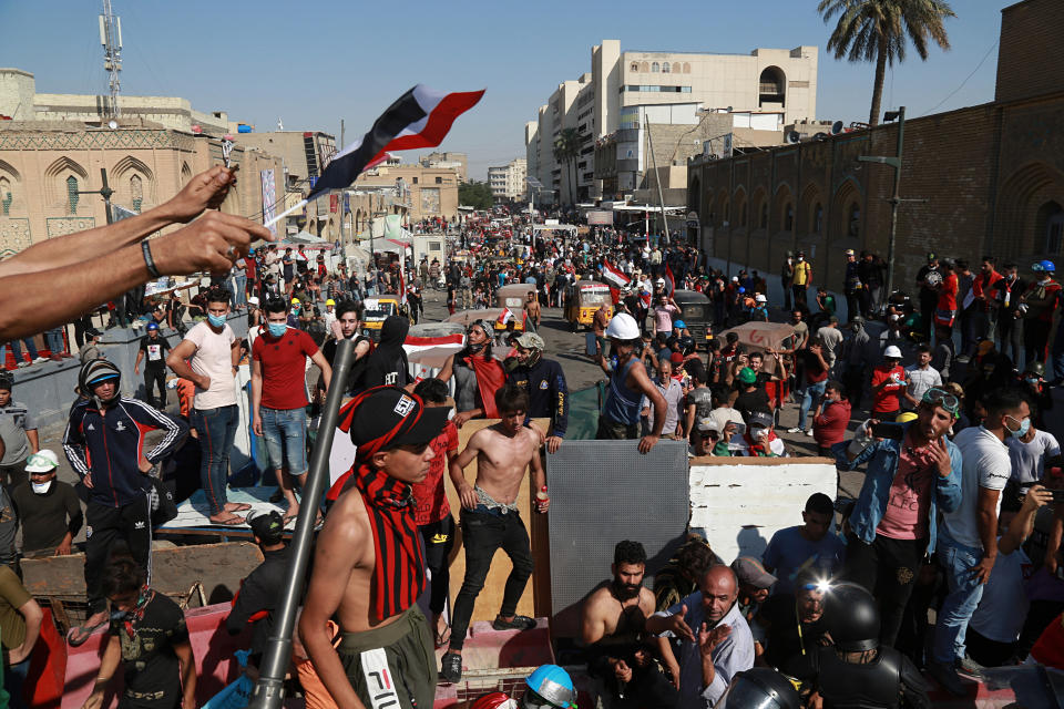 Army soldiers trying to prevent protesters from crossing the al- Shuhada (Martyrs) bridge in central Baghdad, Iraq, Wednesday, Nov. 6, 2019. (AP Photo/Khalid Mohammed)