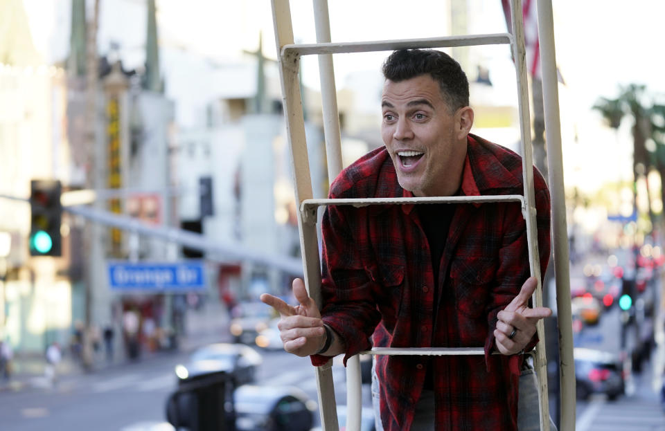 Steve-O, a cast member in the film "Jackass Forever," poses for a portrait on a fire escape above Hollywood Blvd. at the Hollywood Roosevelt in Los Angeles on Jan. 27, 2022. (AP Photo/Chris Pizzello)