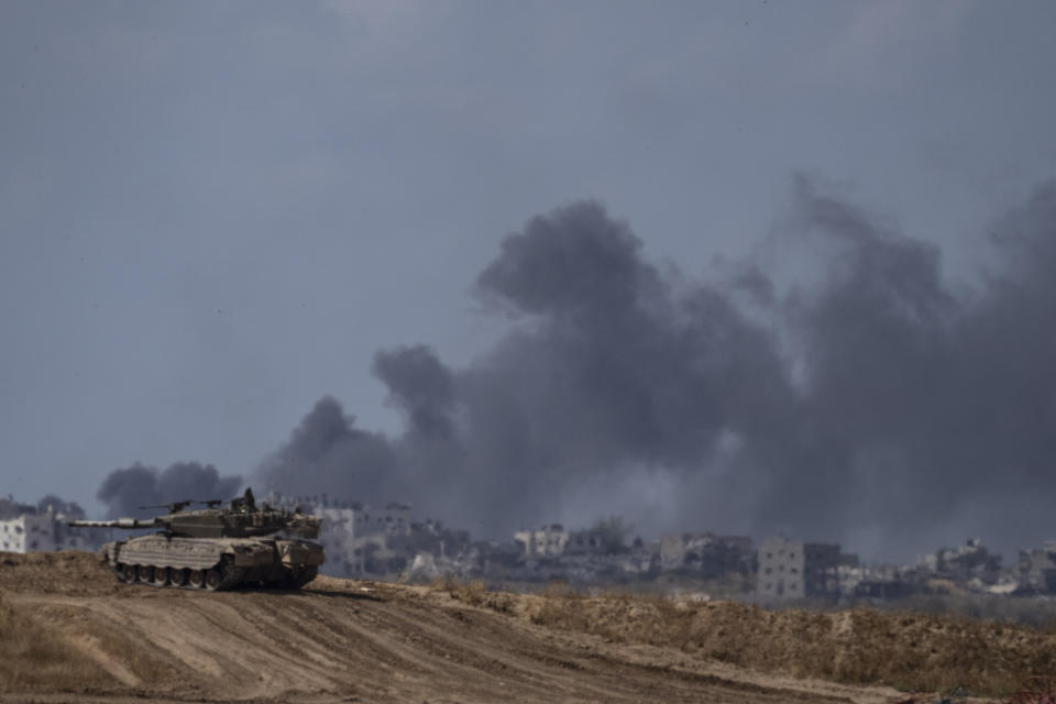 Backdropped by smoke rising to the sky after an explosion in the Gaza Strip, an Israeli tank stands near the Israel-Gaza border as seen from southern Israel, Monday, May 13, 2024. (AP Photo/Leo Correa)