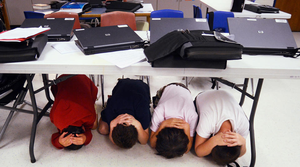 Fifth-graders take cover under a table during an earthquake drill at Hilton Head Island Elementary School on Thursday, Oct. 18, 2012. The drill was part of the 2012 Great Southeast "ShakeOut," sponsored by the Federal Emergency Management Agency. (AP Photo/The Island Packet, Jay Karr)