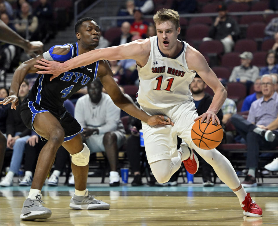 Saint Mary's center Mitchell Saxen (11) drives the ball against BYU forward Atiki Ally Atiki (4) during the first half of an NCAA college basketball game in the semifinals of the West Coast Conference men's tournament Monday, March 6, 2023, in Las Vegas. (AP Photo/David Becker)