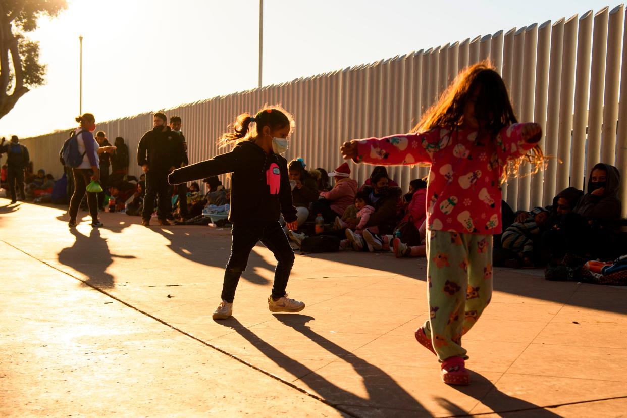 <p>Children play as families of asylum seekers wait outside the El Chaparral border crossing port as they wait to cross into the United States in Tijuana, Baja California state, Mexico on February 19, 2021</p> (Photo by PATRICK T. FALLON/AFP via Getty Images)